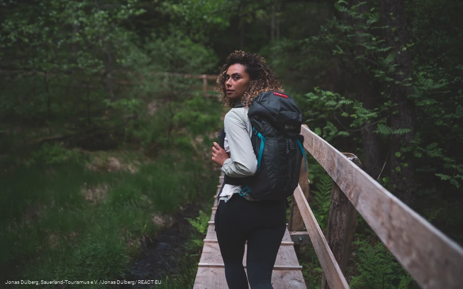 Wandererin auf dem Holzsteg in den Ebbemooren
